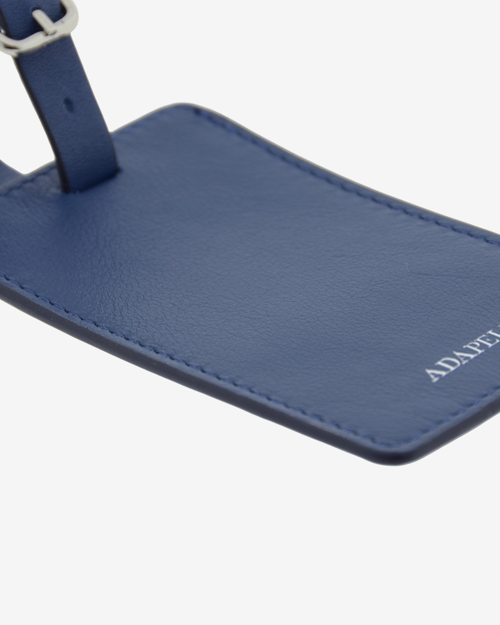Tag identificador maleta con cierre de hebilla, ref. 8088-20, en piel de color azul marino y cantos en negro, con logo Adapell, vista detalle de piel y acabados premium