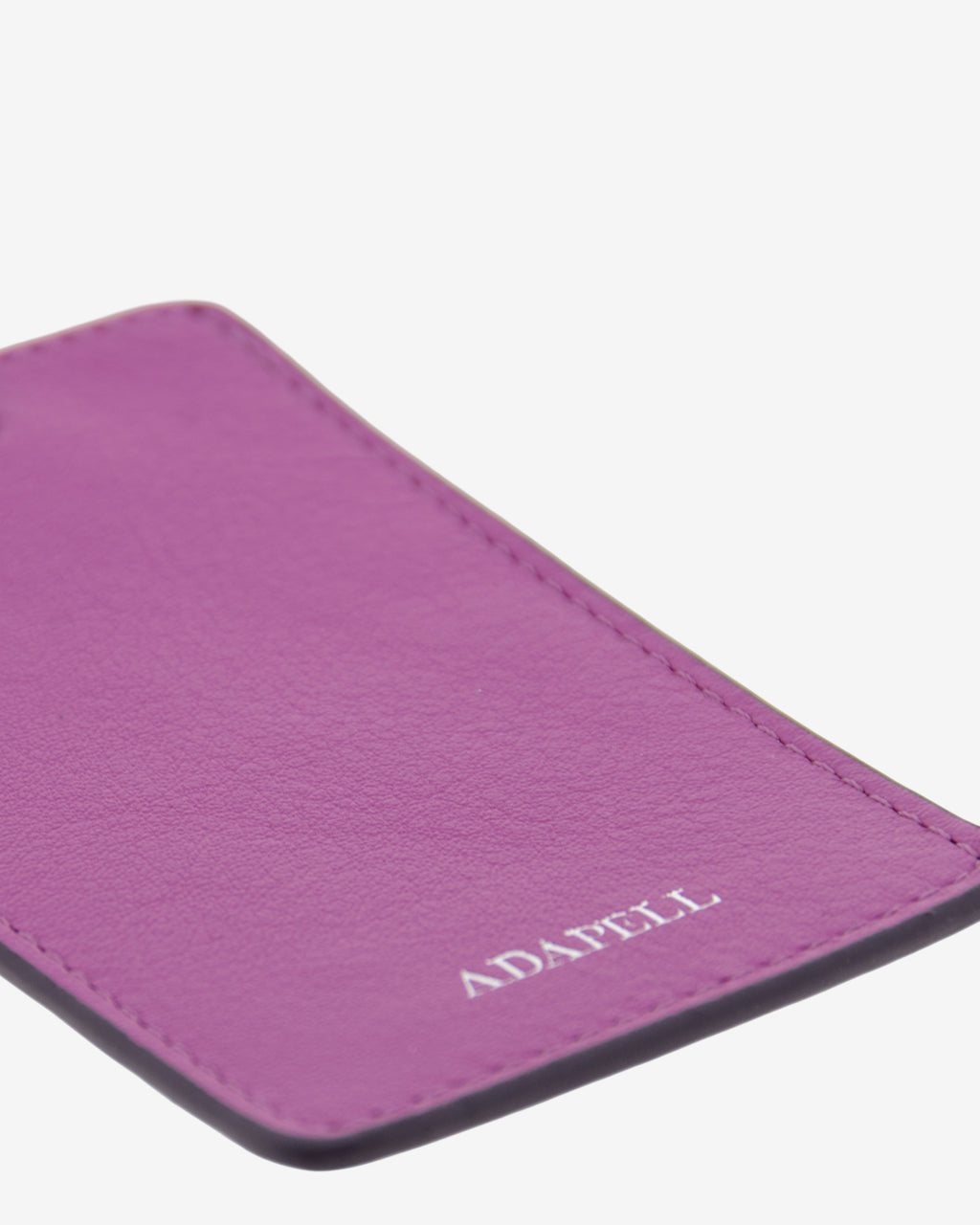 Tag identificador maleta con cierre de hebilla, ref. 8088-4, en piel de color lila y cantos en negro, con logo Adapell, vista detalle de piel y acabados