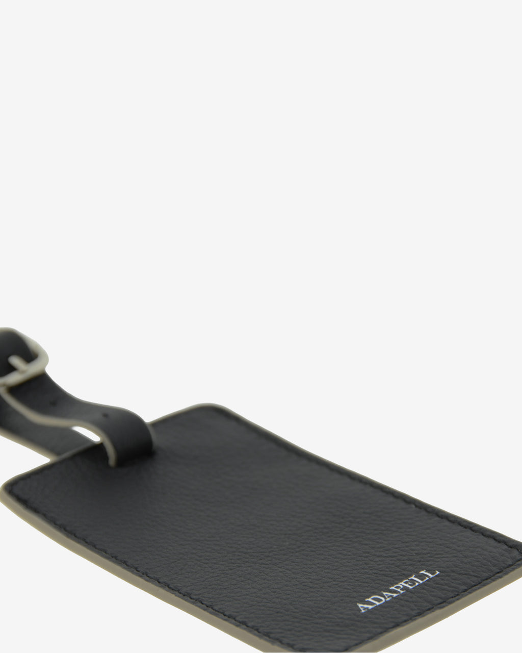 Tag identificador maleta con cierre de hebilla, ref. 8088-1, en piel de color negro y cantos en gris, con logo Adapell, vista detalle piel y acabados