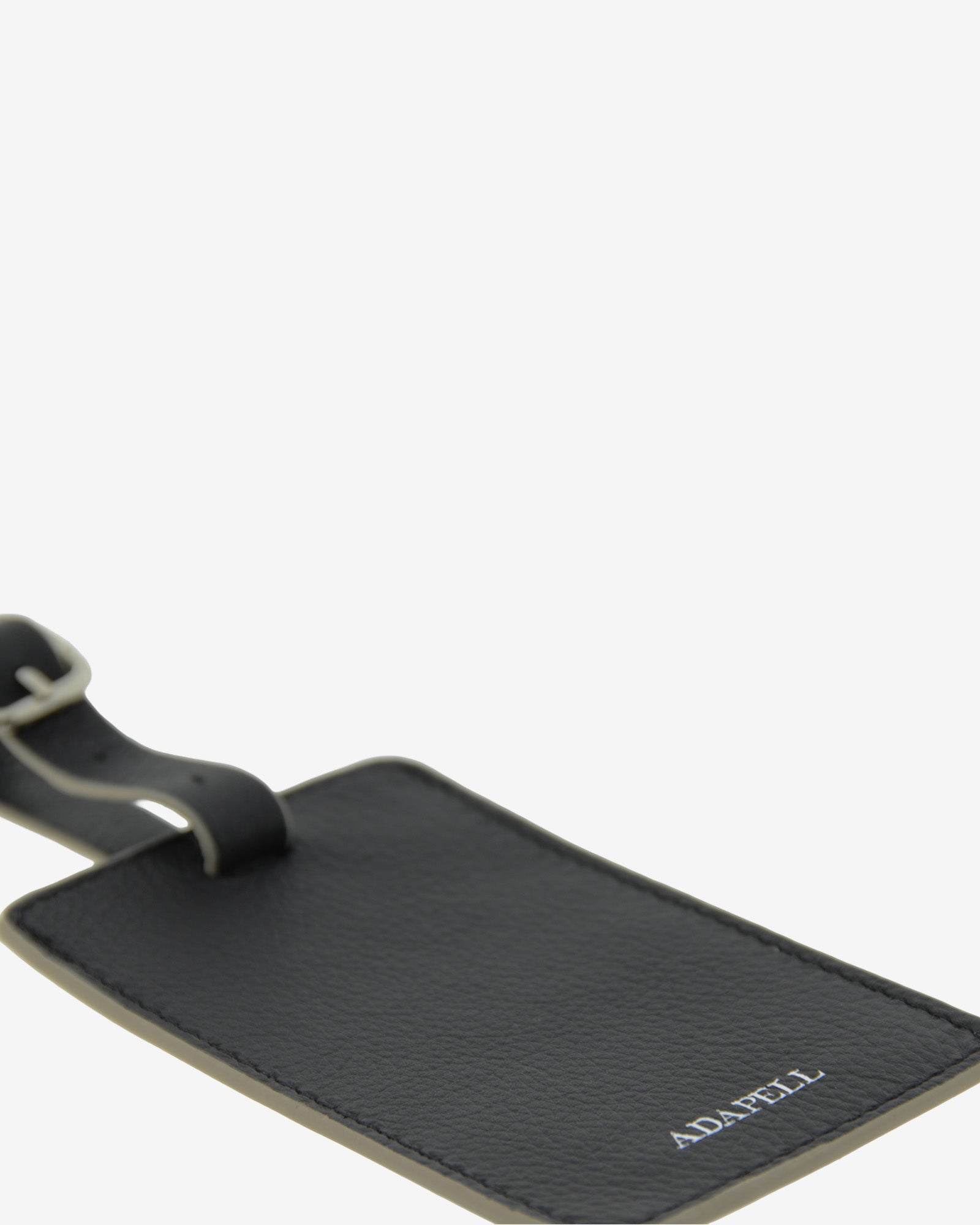 Tag identificador maleta con cierre de hebilla, ref. 8088-1, en piel de color negro y cantos en gris, con logo Adapell, vista detalle piel y acabados