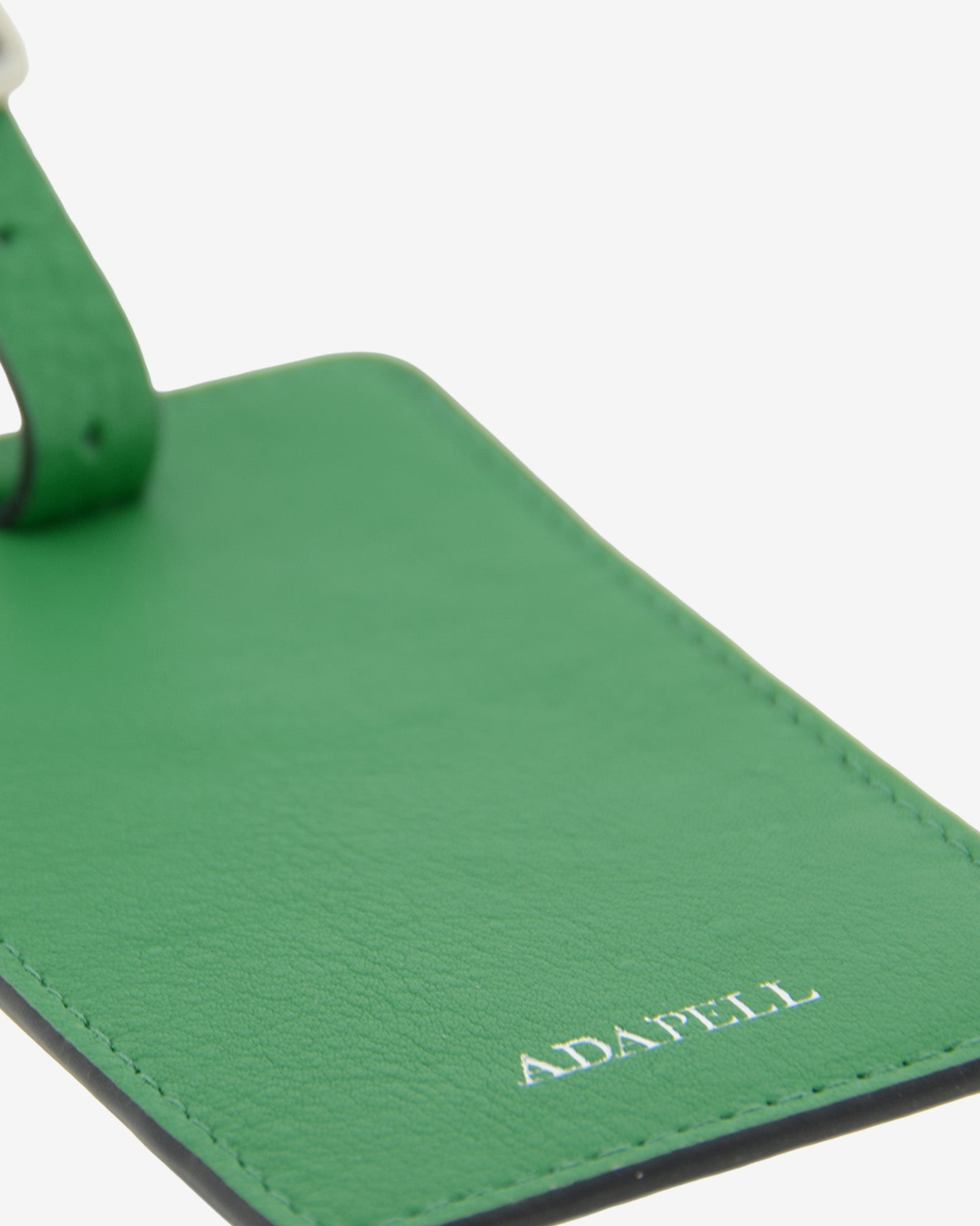 Tag identificador maleta con cierre de hebilla, ref. 8088-5, en piel de color verde y cantos en negro, con logo Adapell, vista detalle de piel
