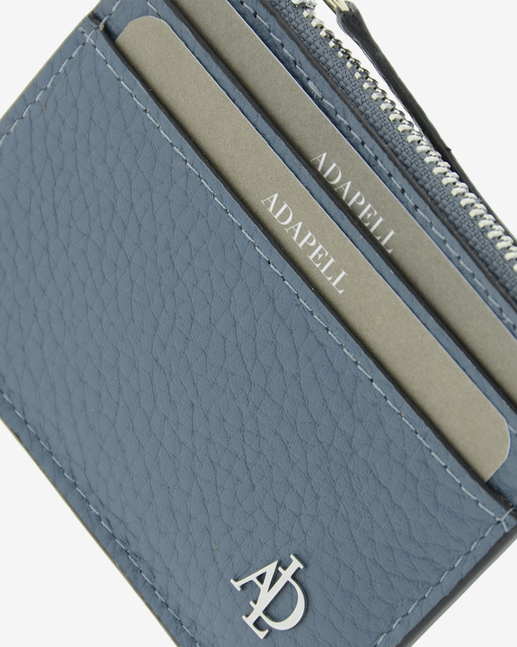 Tarjetero de piel auténtica granulada de alta calidad, ref. 4259-14 en color azul blue stone, con protección de tarjetas RFID y monedero central con cremallera, de la colección Nude, vista detalle de piel, composición tarjetas y logo Adapell