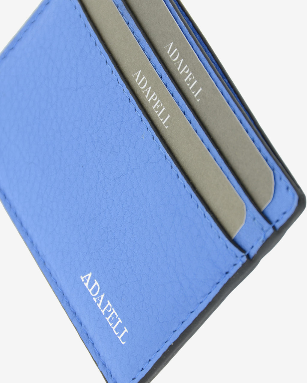 Tarjetero ultrafino en piel auténtica de color azul con bordes en negro, ref. 8083-14, con capacidad para 4 tarjetas y compartimento central para billetes o más tarjetas y con protección de tarjetas RFID, vista detalle de piel, acabados y logo Adapell