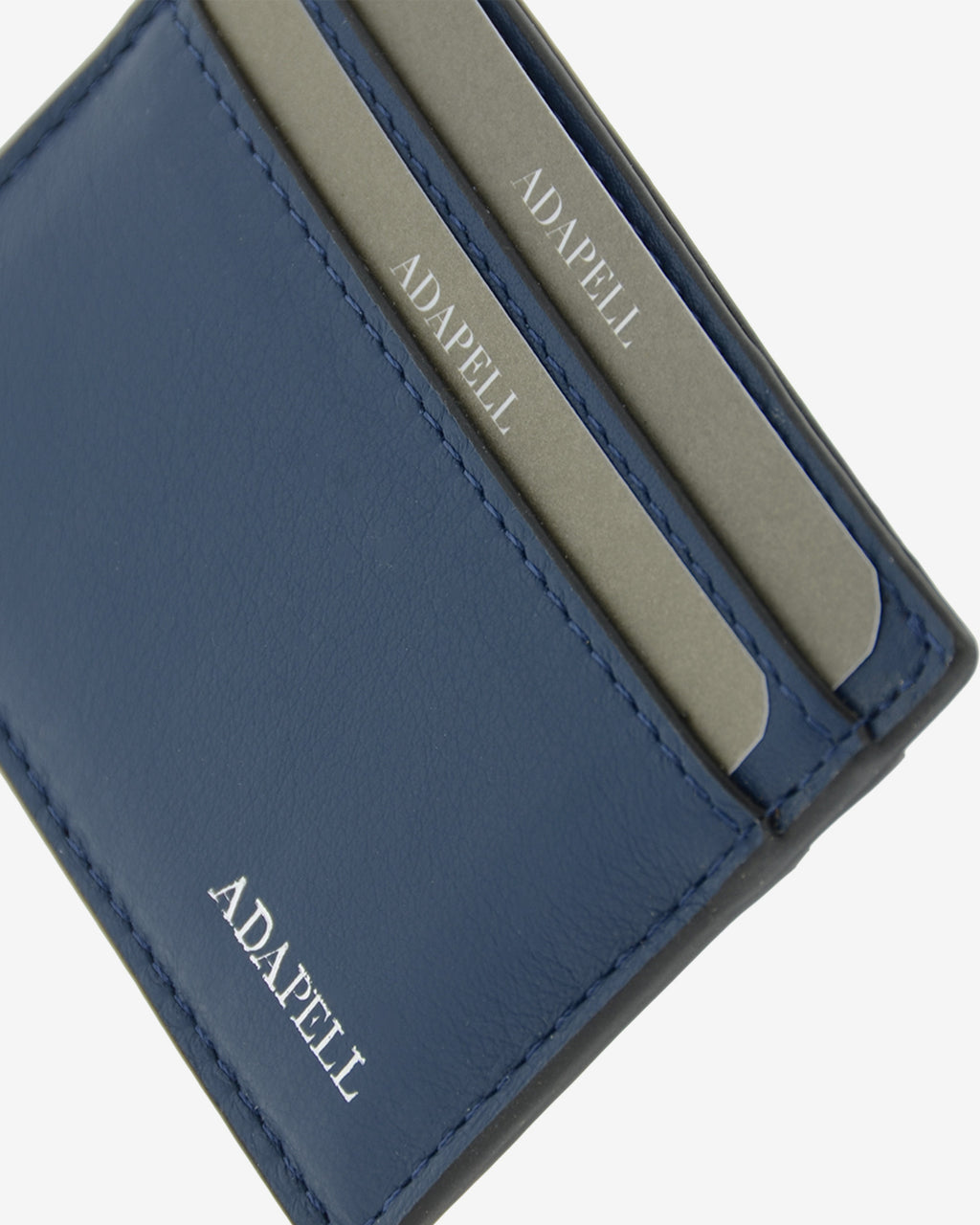 Tarjetero ultrafino en piel auténtica de color azul marino con bordes en negro, ref. 8083-20, con capacidad para 4 tarjetas y compartimento central para billetes o más tarjetas y con protección de tarjetas RFID, vista detalle de piel, acabados y logo Adapell