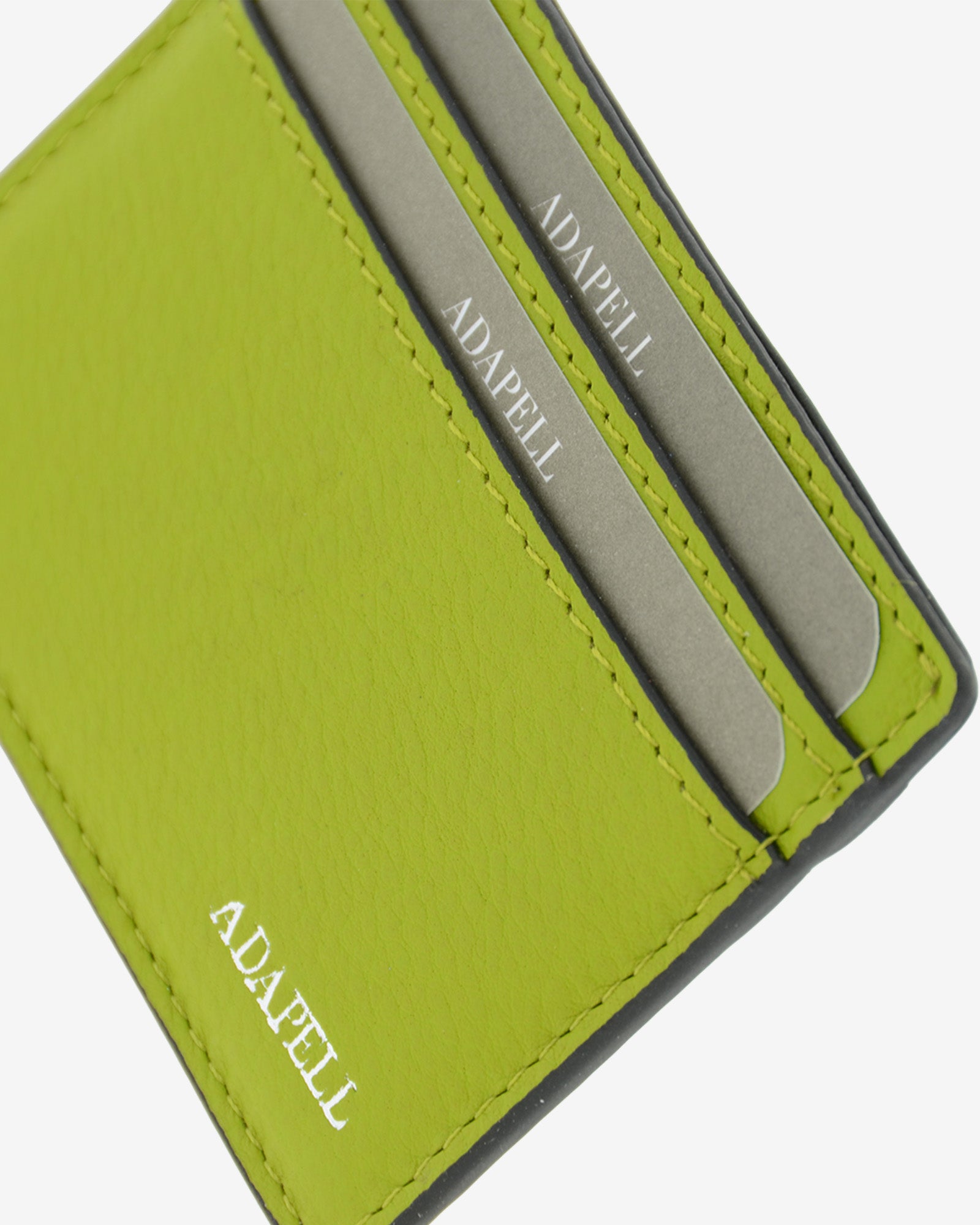 Tarjetero ultrafino en piel auténtica de color lima con bordes en negro, ref. 8083-17, con capacidad para 4 tarjetas y compartimento central para billetes o más tarjetas y con protección de tarjetas RFID, vista detalle de piel, acabados y logo Adapell