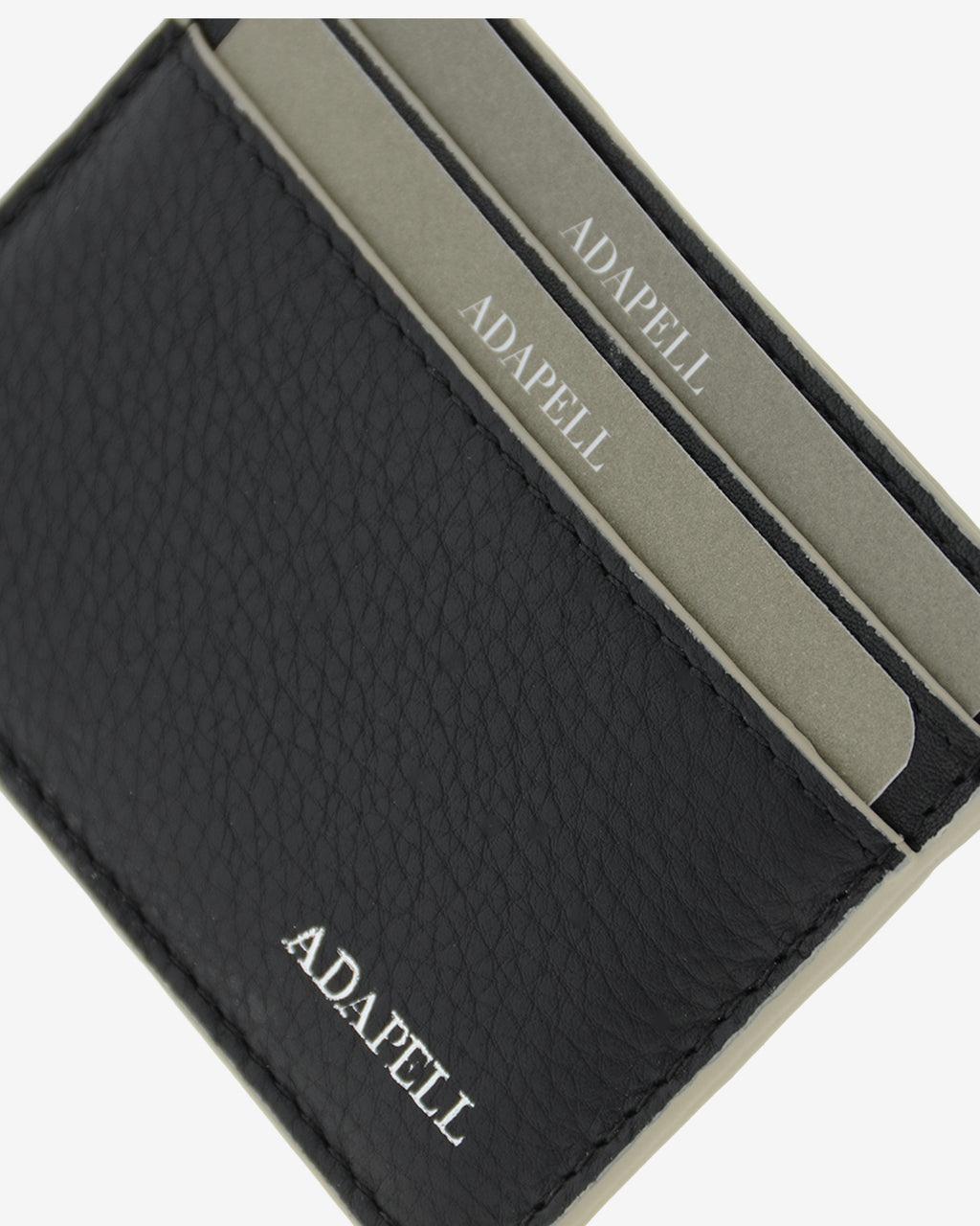 Tarjetero ultrafino en piel auténtica de color negro con ribetes en gris, ref. 8083-1, con capacidad para 4 tarjetas y compartimento central para billetes o más tarjetas y con protección de tarjetas RFID, vista detalle piel de alta calidad, acabados limpios y logo Adapell