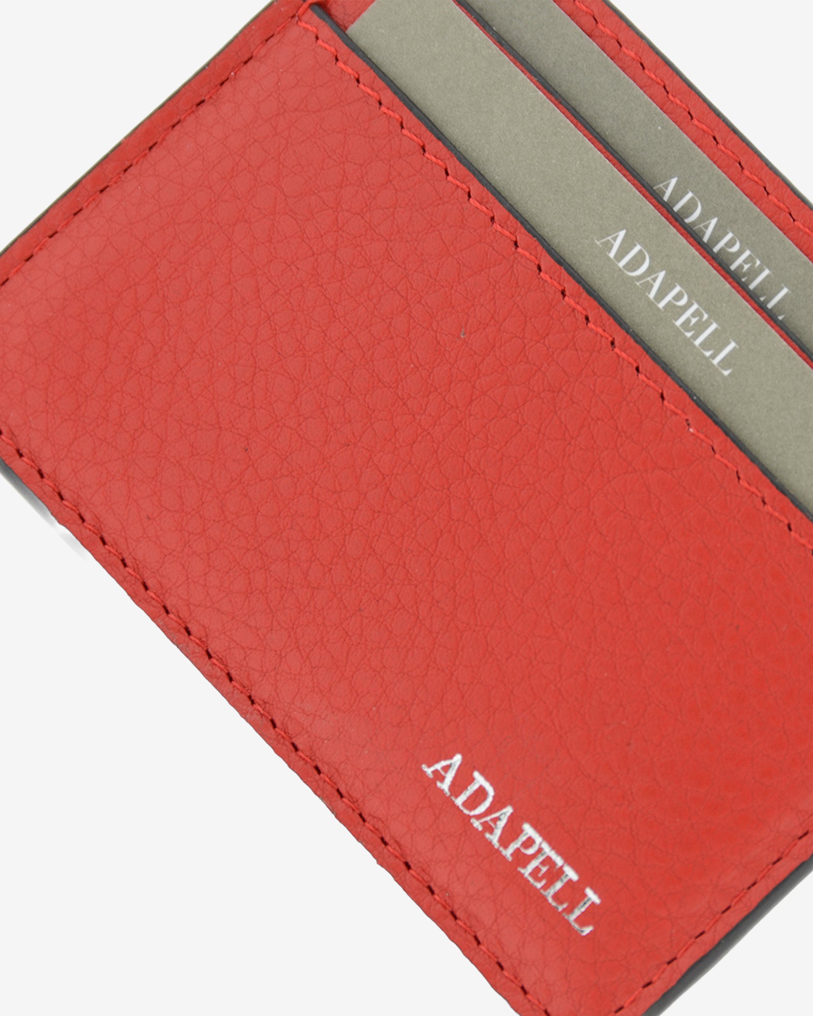 Tarjetero ultrafino en piel auténtica de color rojo con bordes en negro, ref. 8083-3, con capacidad para 4 tarjetas y compartimento central para billetes o más tarjetas y con protección de tarjetas RFID, vista detalle de piel, acabados y logo Adapell