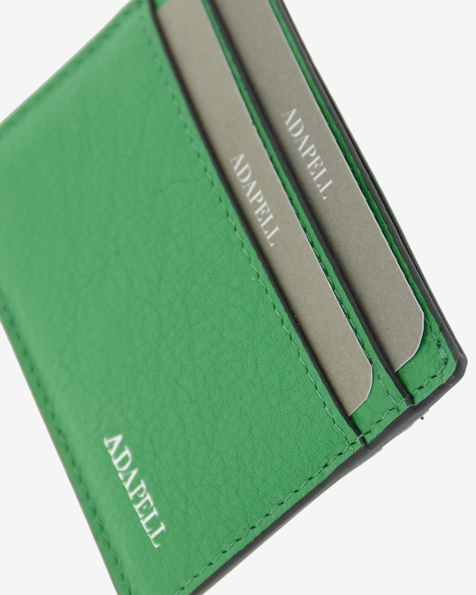 Tarjetero ultrafino en piel auténtica de color verde con bordes en negro, ref. 8083-5, con capacidad para 4 tarjetas y compartimento central para billetes o más tarjetas y con protección de tarjetas RFID, vista detalle de piel, acabados premium y logo Adapell